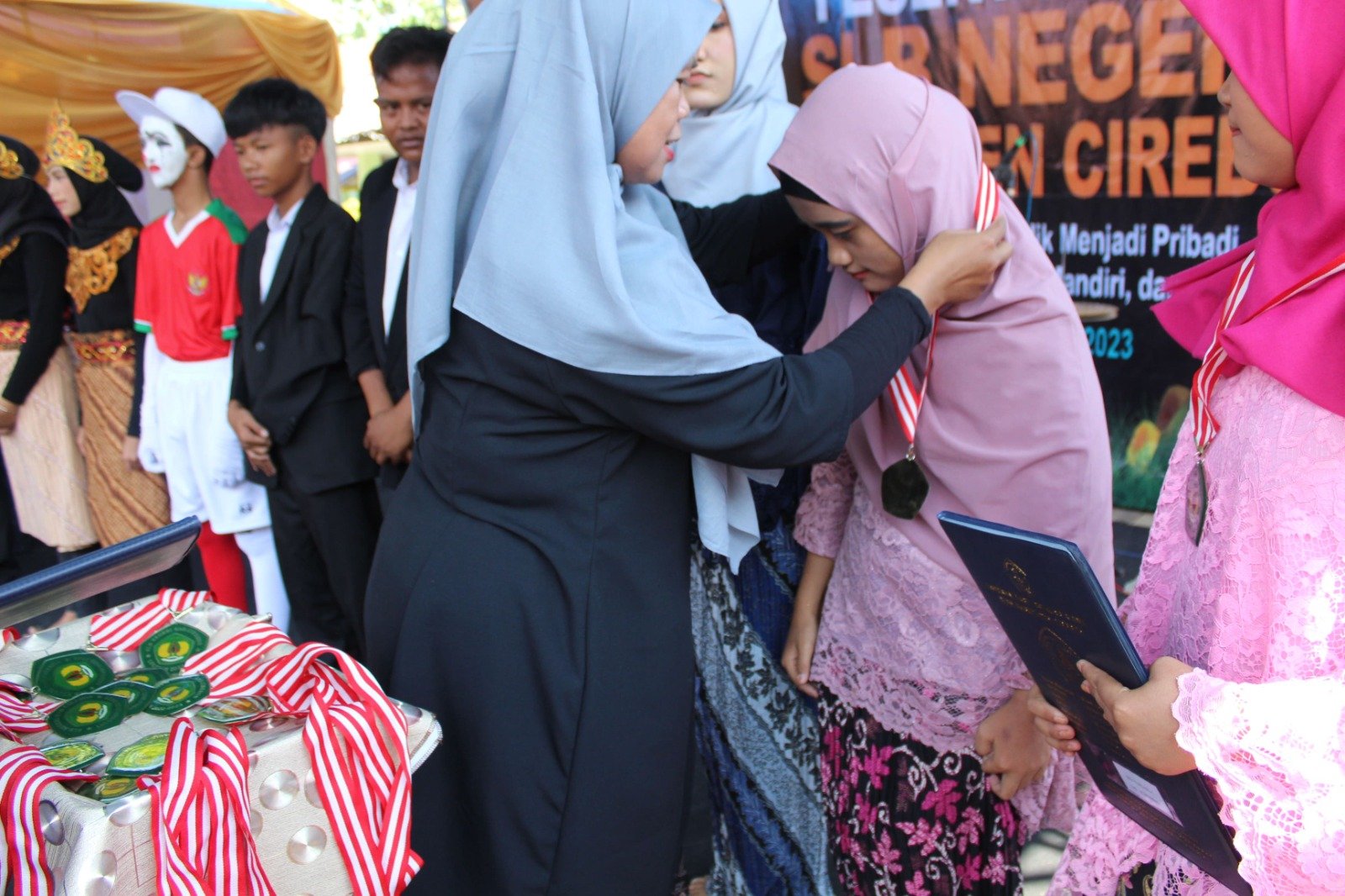 Aksi Mengalungkan Medali kepada Peserta SIswa