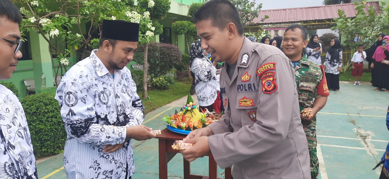 Pemberian Bingkisan Coklat oleh Anggota Polisi kepada Guru