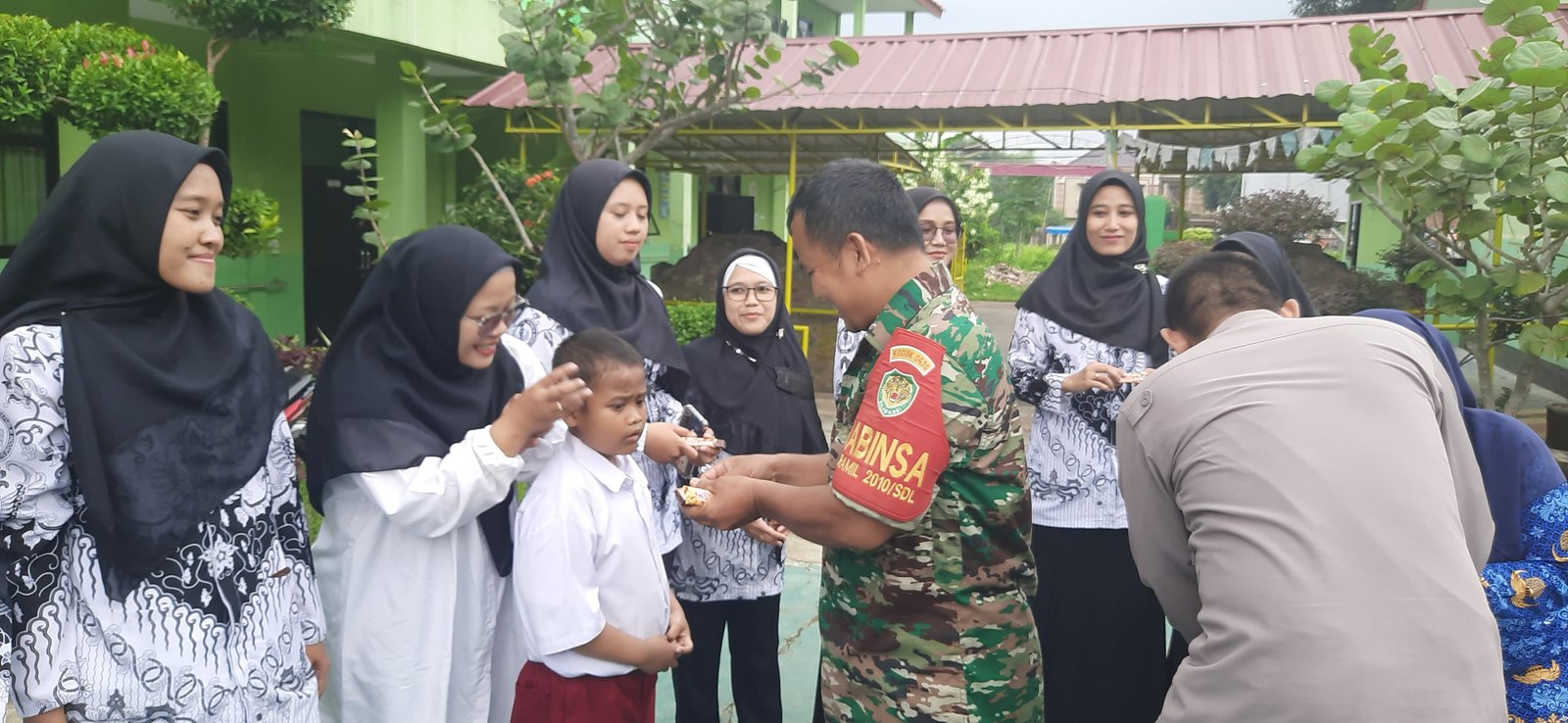 Pemberian Bingkisan Coklat oleh Anggota TNI kepada Guru