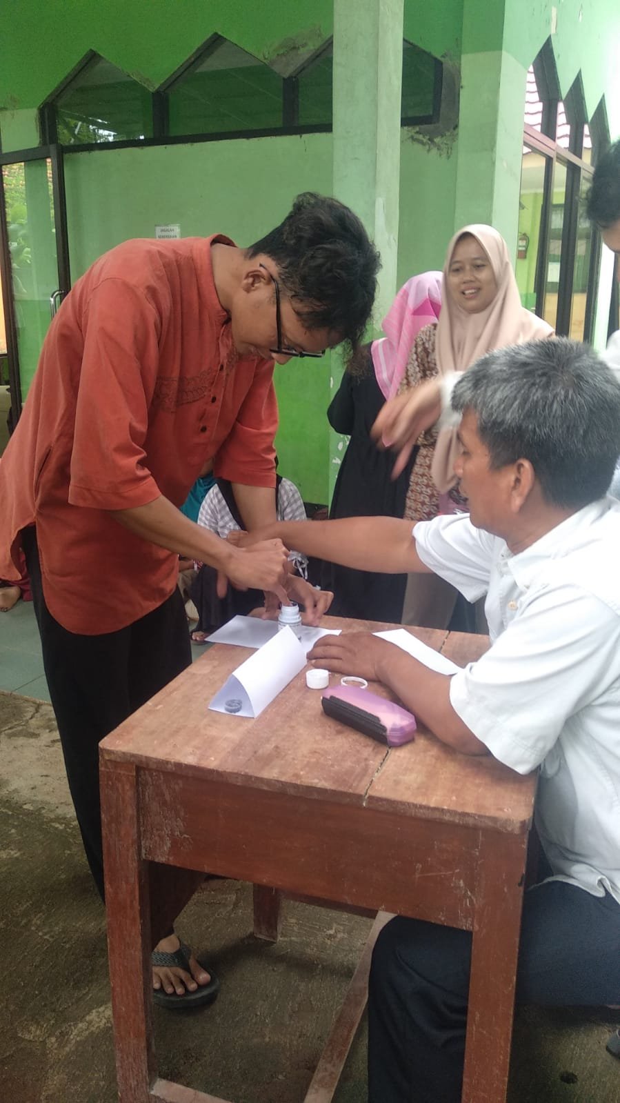 Peserta didik memasukan jari ke dalam Tinta sebagai bukti dia telah melakukan Pencoblosan Pemilu 2024